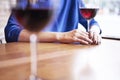 Woman is drinking red wine and having rest in cafe near window, close-up of womanÃ¢â¬â¢s hands holding glass on table Royalty Free Stock Photo